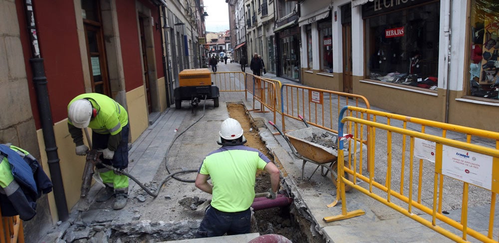 Dos operarios realizando los trabajos de soterramiento de la instalación eléctrica en la calle Martín de Lugones.