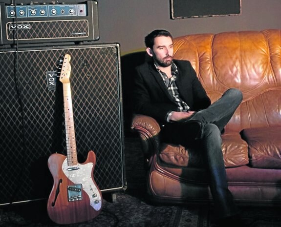 El músico Alfredo González junto a su guitarra en una foto de promoción realizada por Arnold Moolenaar. :: e. c.