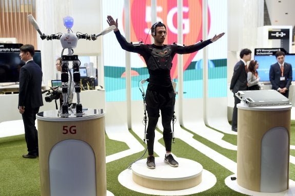 Un hombre maneja con su cuerpo un robot conectado a una red inalámbrica en el congreso de telefonía móvil de Barcelona. :: afp