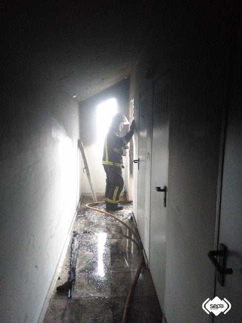Un bombero, en el interior del edificio en el que se declaró el incendio en Vegadeo. :: Bomberos de asturias