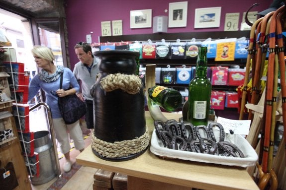 Dos turistas británicos buscan un recuerdo en Todo Astur, una tienda especializada de la calle Rui Gómez. 