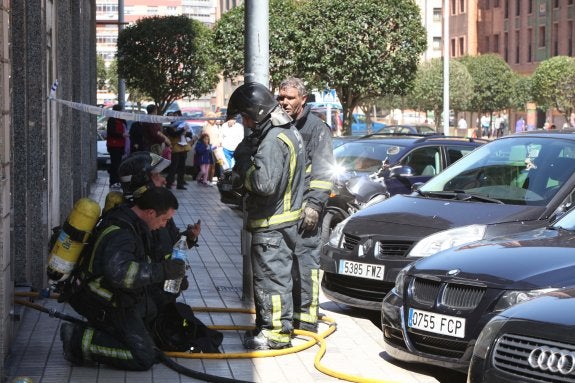 Un grupo de bomberos descansa y se hidrata poco después de salir del interior del garaje. 