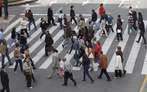 Peatones cruzan una calle de Oviedo. 