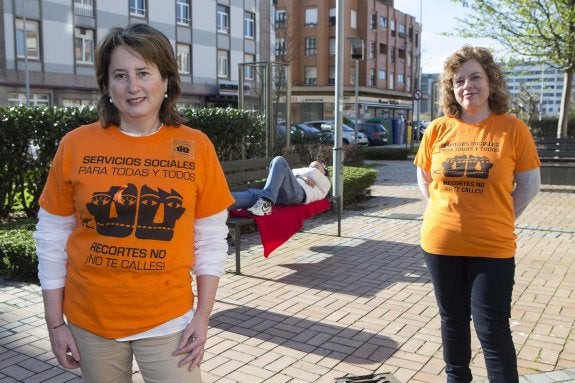 Esperanza Calderero y Belén Murillo, portavoces de la Plataforma en Defensa del Sistema Público de Servicios Sociales del Principado, posan en un parque gijonés con las camisetas reivindicativas de la 'marea naranja'. 