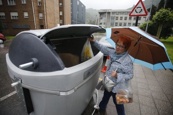 Una vecina deposita su bolsa de basura en uno de los nuevos contenedores habilitados. 