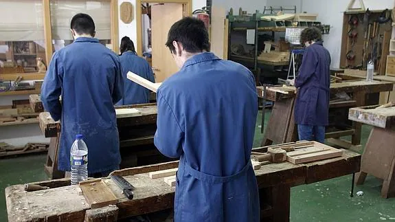 Jóvenes participando en un taller de carpintería del centro de menores. 