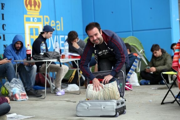 Un aficionado del Oviedo, equipado con su maleta, espera junto al resto de seguidores a que mañana abran las taquillas. 
