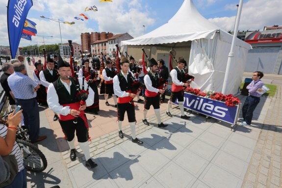 La Banda de Gaitas de Corvera, con su director, Bras Rodrigo, en primer término,  inicia el recorrido inaugural de Bitácora, la III Semana de la Mar de Avilés, instalada a lo largo del paseo de la ría. 