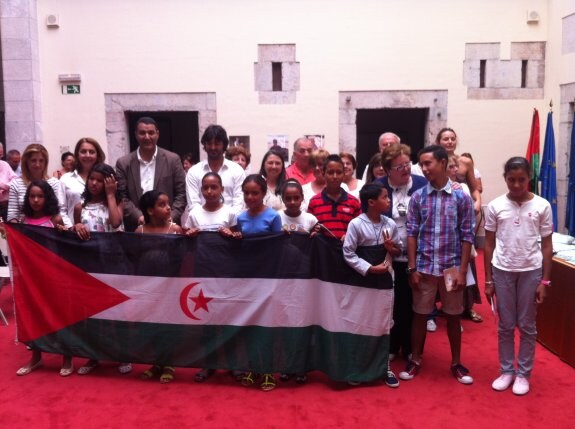 Foto de familia con la bandera del Sáhara Occidental y los 11 niños del programa 'Vacaciones en Paz. 