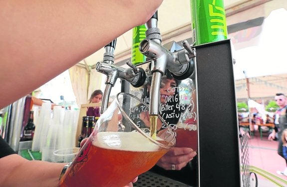 Una camarera tira una caña en el festival de la cerveza. 