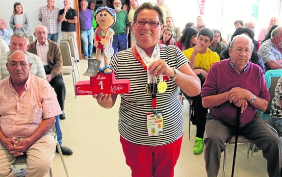 María Antonia Martínez muestra sus medallas y uno de los detalles recibidos ayer en el homenaje. 
