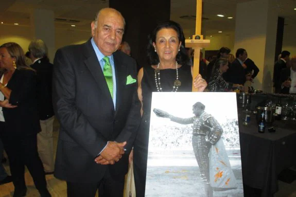 Carlos Zúñiga, empresario de El Bibio, y su esposa Nardi, con la foto regalada por un grupo de aficionados donde se le ve de novillero.
