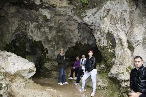 Un grupo de personas espera para acceder a la cueva de El Buxu, en Cangas de Onís. 