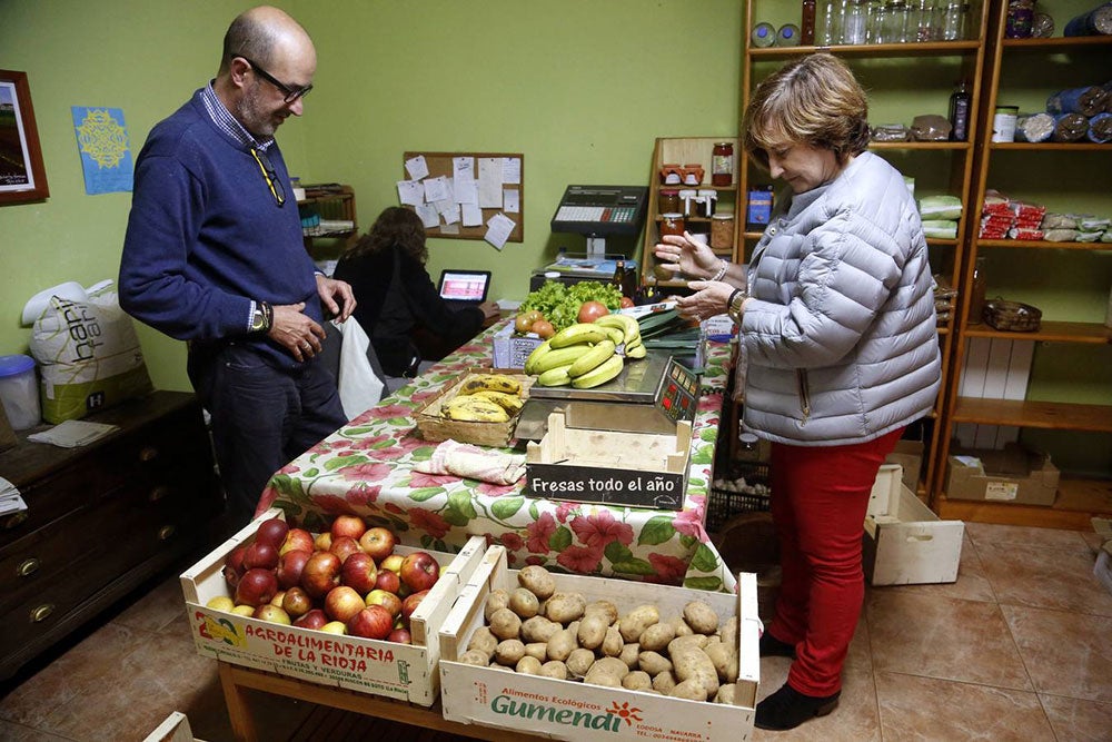 Julian Sánchez pesa los productos a la clienta Begoña Contreras.