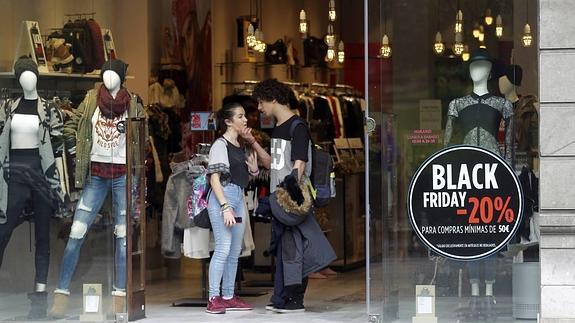 Dos jóvenes ante una tienda de Oviedo. 