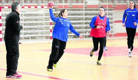 Dueñas observa a las dos jugadoras descartadas, Ana Temprano y Bea Fernández, en primer plano, junto a Eli Chávez, a la derecha, ayer, en el Palacio, en el último entrenamiento de la selección en Asturias. 