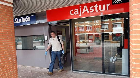 Un agente de la Policía Judicial saliendo de la oficina de Liberbank el día del atraco. 