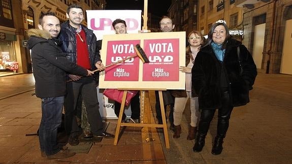 Adán Fernández, a la izquierda, durante la pegada de carteles.