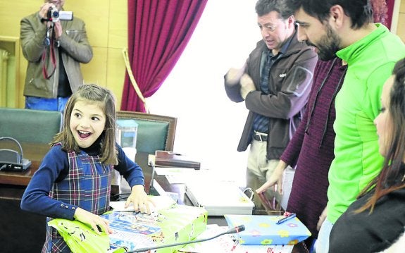 Lucía Santos abre su regalo. 