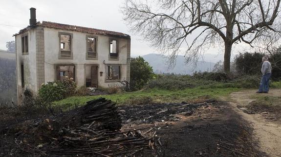 Un hombre observa el rastro de la destrucción provocada por el fuego en La Caridad.