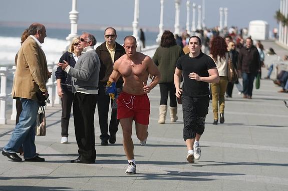 Dos personas corren por el Muro mientras otras pasean animadamente.