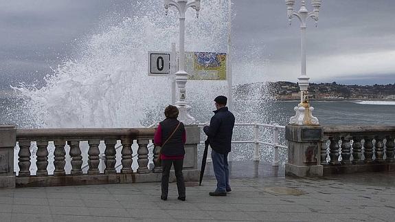 Una ola rompe contra el Muro de San Lorenzo, en la escalera de La Cantábrica, durante el temporal