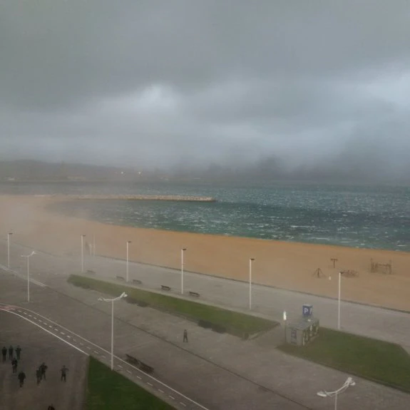 Las fuertes rachas de viento levantaron nubes de carbón en El Musel y de arena en la playa de Poniente ayer por la tarde. :: CHELO TUYA