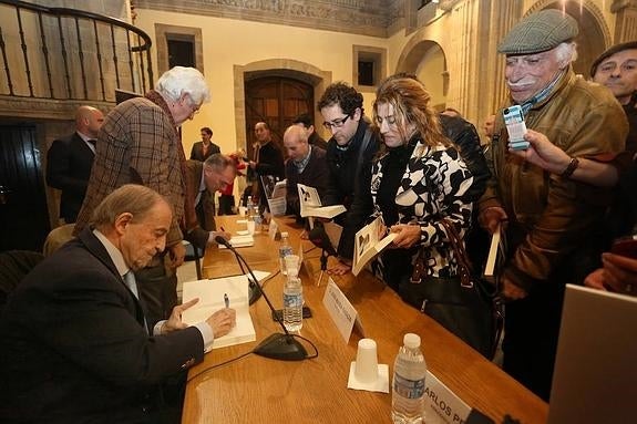 El periodista José María García firma ejemplares de su biografía, escrita por el periodista Vicente Ferrer -en segundo término, también firmando-, en La Colegiata San Juan Bautista de Gijón. 