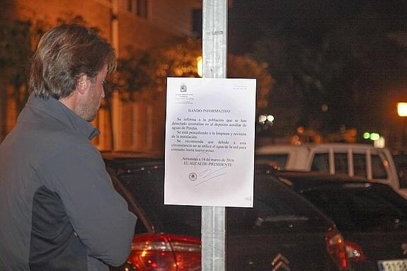 Un hombre lee uno de los bandos emitidos por el Ayuntamiento de Parres para informar a la población de la incidencia. 