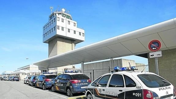 Varios coches de Policía en el aeropuerto de Asturias, junto a la torre de control.
