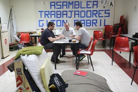 Tres de los trabajadores de Gijón Fabril, encerrados ayer en la nave de Porceyo. 