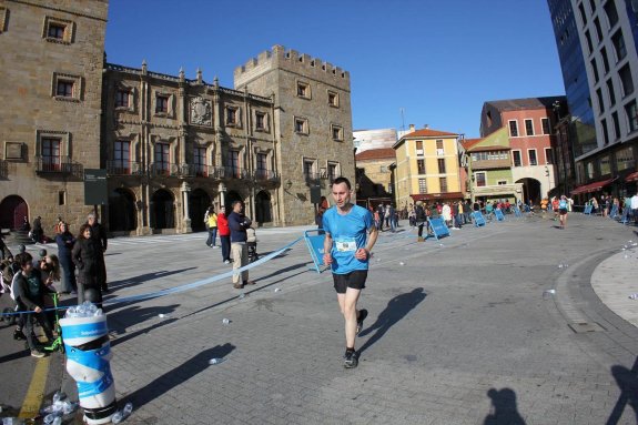 Alejandro Álvarez, que falleció mientras participaba en el Medio Maratón de Gijón, a su paso por el palacio de Revillagigedo. 