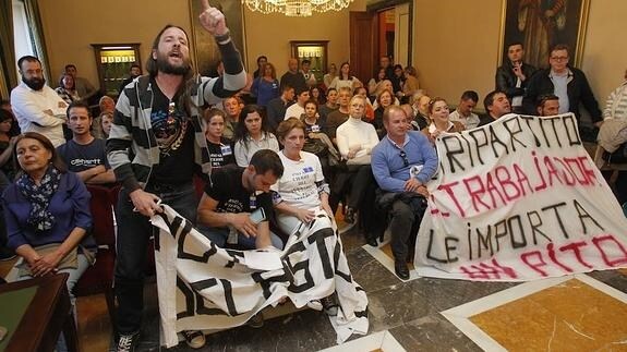 Los trabajadores del centro ecuestre de El Asturcón exhibieron hoy varias pancartas en el Pleno de Oviedo.