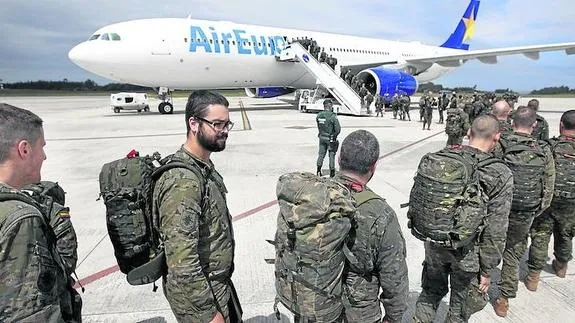 Soldados hacen cola en la pista del aeropuerto de Asturias para embarcar en el avión de Air Europa que les trasladó a Polonia. 