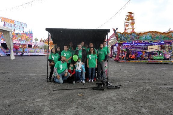 El pregonero Nacho Carballo posa con la comsión de fiestas de Nuevo Roces en el aparcamiento del campo de fútbol. 