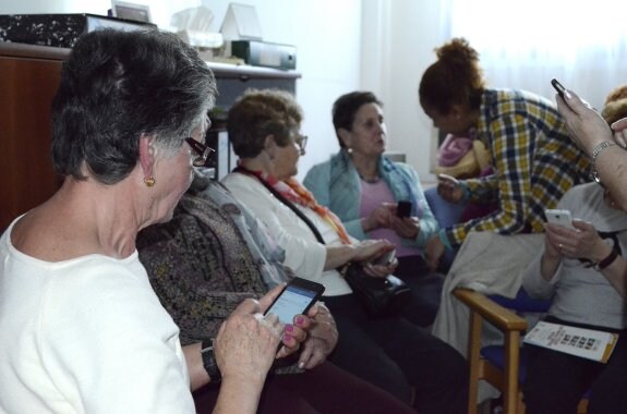 La monitora Bélgica Rodríguez, al fondo, resuelve las dudas de una de las alumnas. 