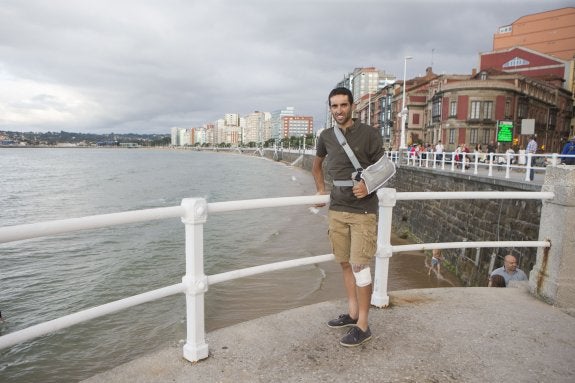 El ciclista gijonés Dani Navarro, con el brazo en cabestrillo y la rodilla izquierda vendada, en el paseo del Muro. 
