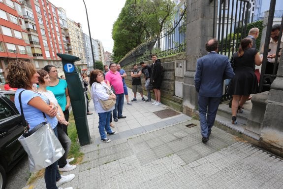 Trabajadores observan la entrada del consejo. 