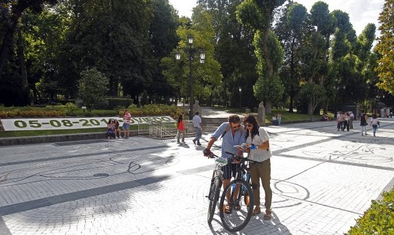 Una pareja, en el Paseo de los Álamos, ayer, delante del calendario del Campo de San Francisco. 