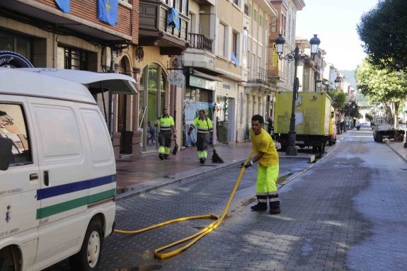 Operarios de limpieza recogiendo mangueras en la calle Gran Vía antes del mediodía. 