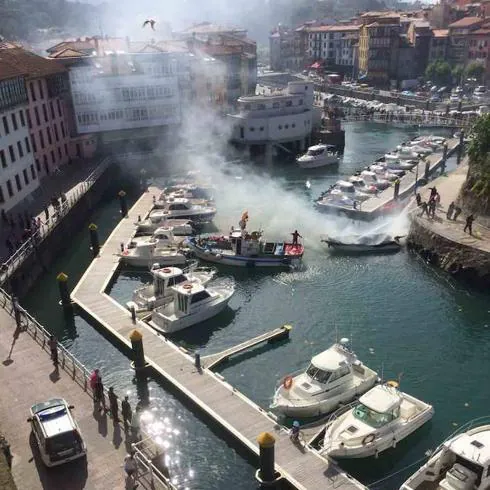 Los bomberos sofocan el incendio de la lancha en el puerto deportivo, situado en el centro de la villa, y que causó gran expectación.