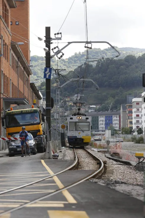 Un tren circula por el paso a nivel de Valnalón. 