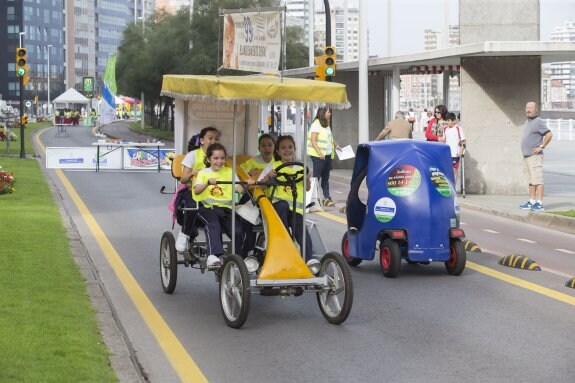 Varias niñas montan en un singular vehículo a pedales por Rufo García Rendueles. 