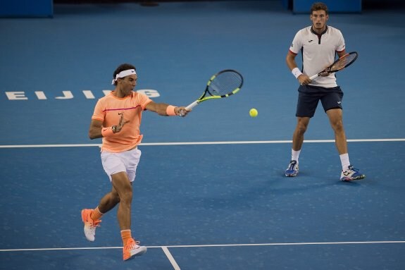 Rafa Nadal devuelve la bola, ante la mirada de su compañero, el gijonés Pablo Carreño. 