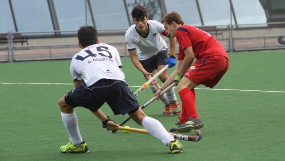 El grupista Dani Camacho, entre dos jugadores cántabros.