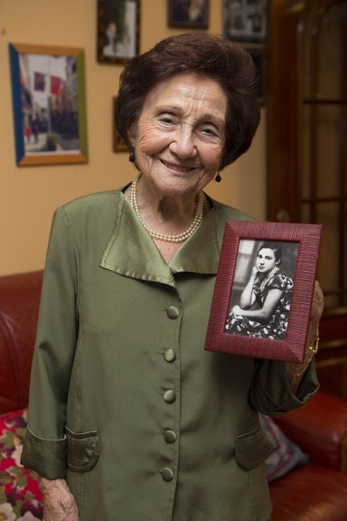 Ángeles Flórez 'Maricuela' muestra una fotografía de sus tiempos mozos en su casa de El Llano. 