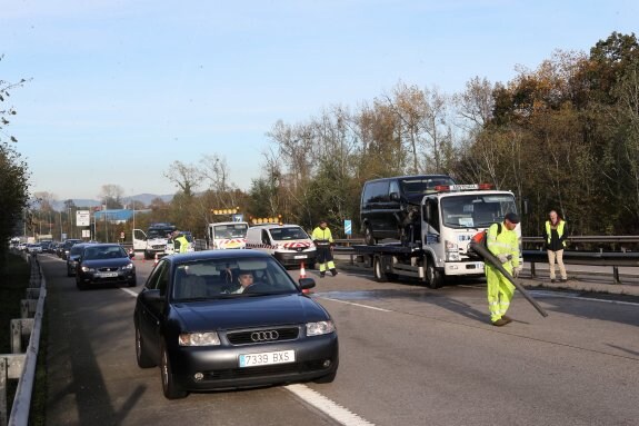 Operarios de Carreteras limpian la zona donde se produjo el accidente. 