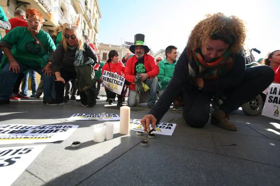 Una joven enciende una vela en la concentración de protesta que se celebró ayer en Reus. Los manifestantes exigieron responsabilidades por el fallecimiento de una octogenaria el lunes, tras el incendio de su casa por una vela con la que se calentaba. 