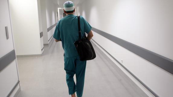 Un médico camina por los pasillos del HUCA.