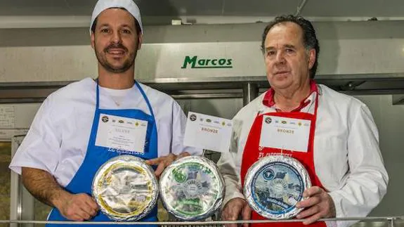 Juan José Fernández Torróntegui, a la izquierda, acompañado por su padre, con quesos de las tres variedades que producen en la quesería El Cabriteru, galardonada en San Sebastián. 